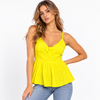 A woman modeling a bright yellow spaghetti-strap peplum top with a gathered center detail, paired with light-wash blue jeans, against a plain white studio background.