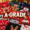 A collage of folded Christmas sweaters in red, green, navy, gray, and black, each with festive knit patterns like reindeer, gingerbread, snowman, candy canes, and pudding. A large red badge with gold lettering reading “A-GRADE” overlays the center.
